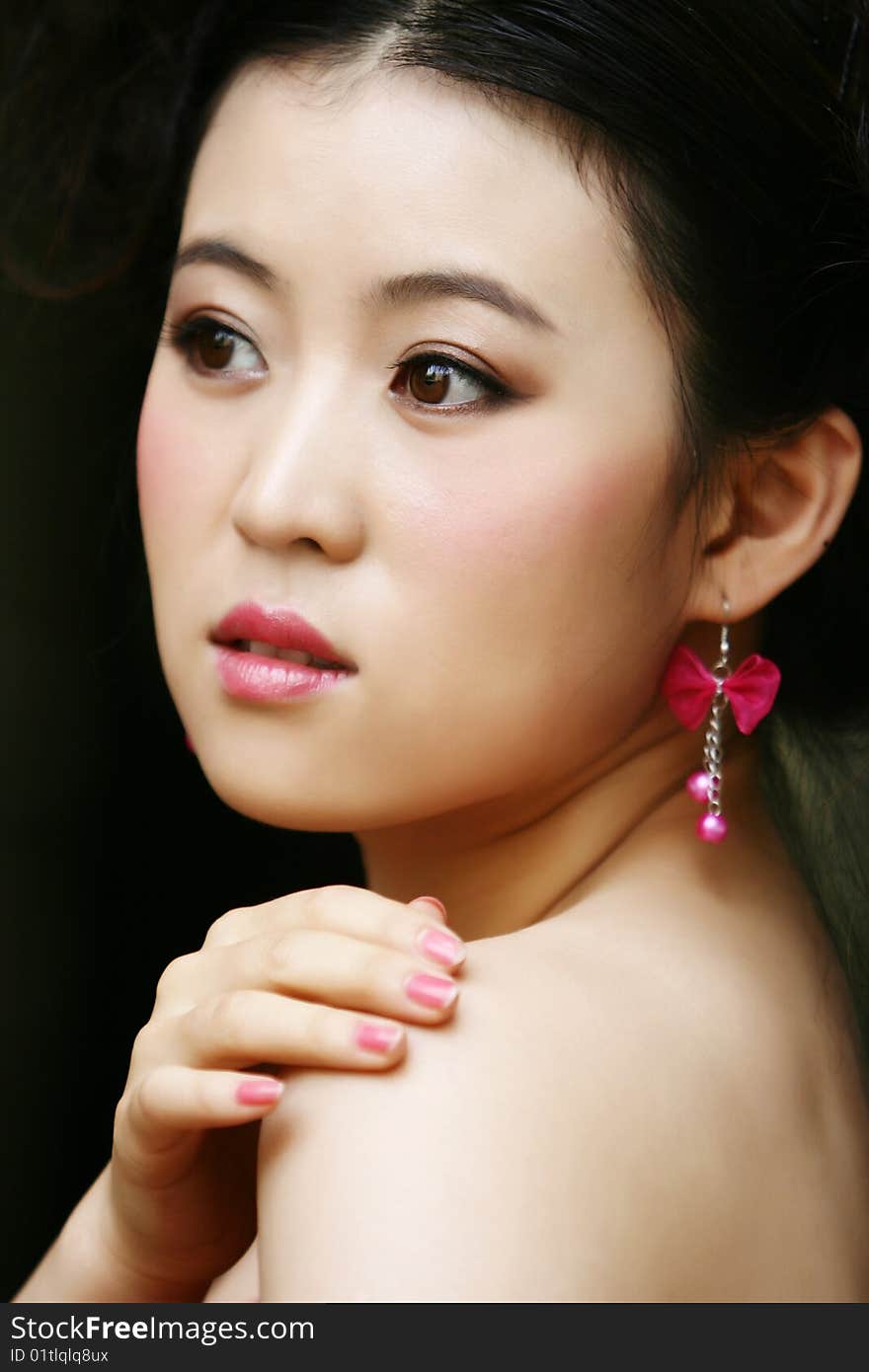 Chinese young lady wears a pink ear ring. Chinese young lady wears a pink ear ring