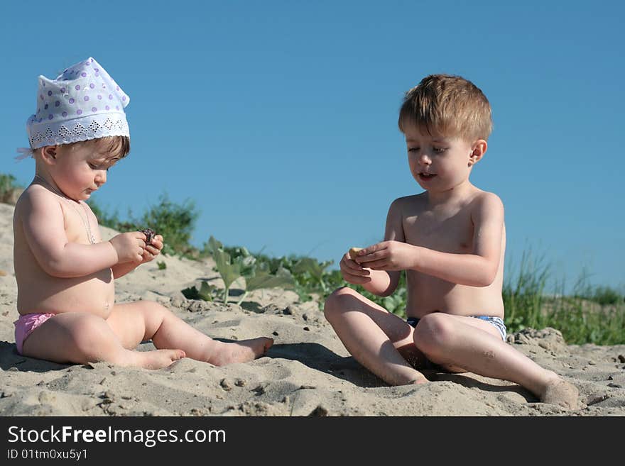 The brother with the sister play on sand. The brother with the sister play on sand