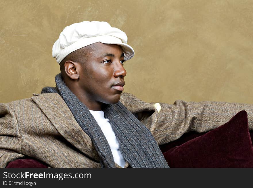 Handsome male model relaxing on a red couch.