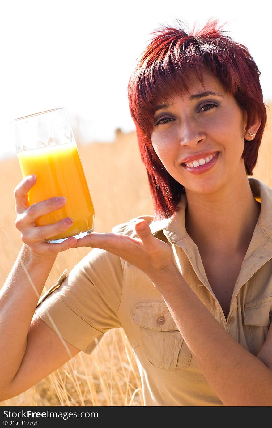 WOMAN DRINKING VITAMIN C ORANGE JUICE OUTDOORS IN NATURE. WOMAN DRINKING VITAMIN C ORANGE JUICE OUTDOORS IN NATURE