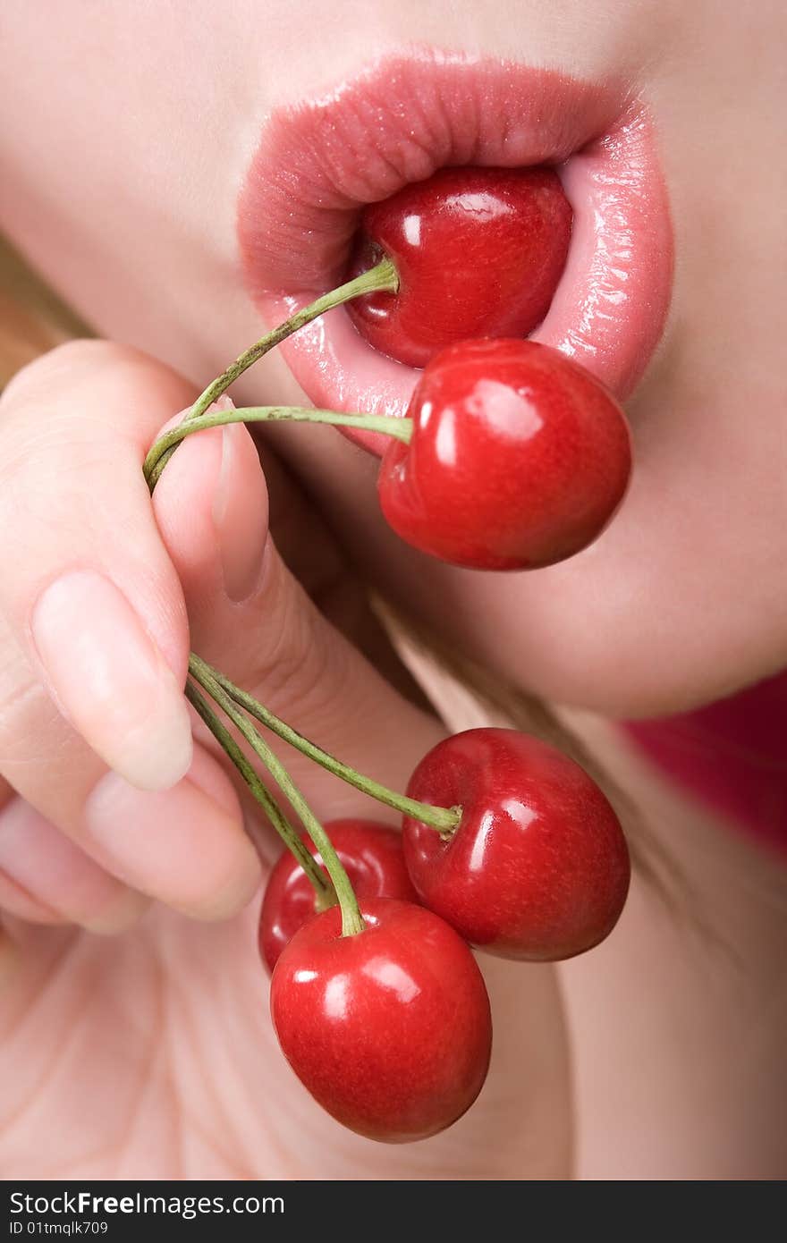 Healthy young woman eating red cherries