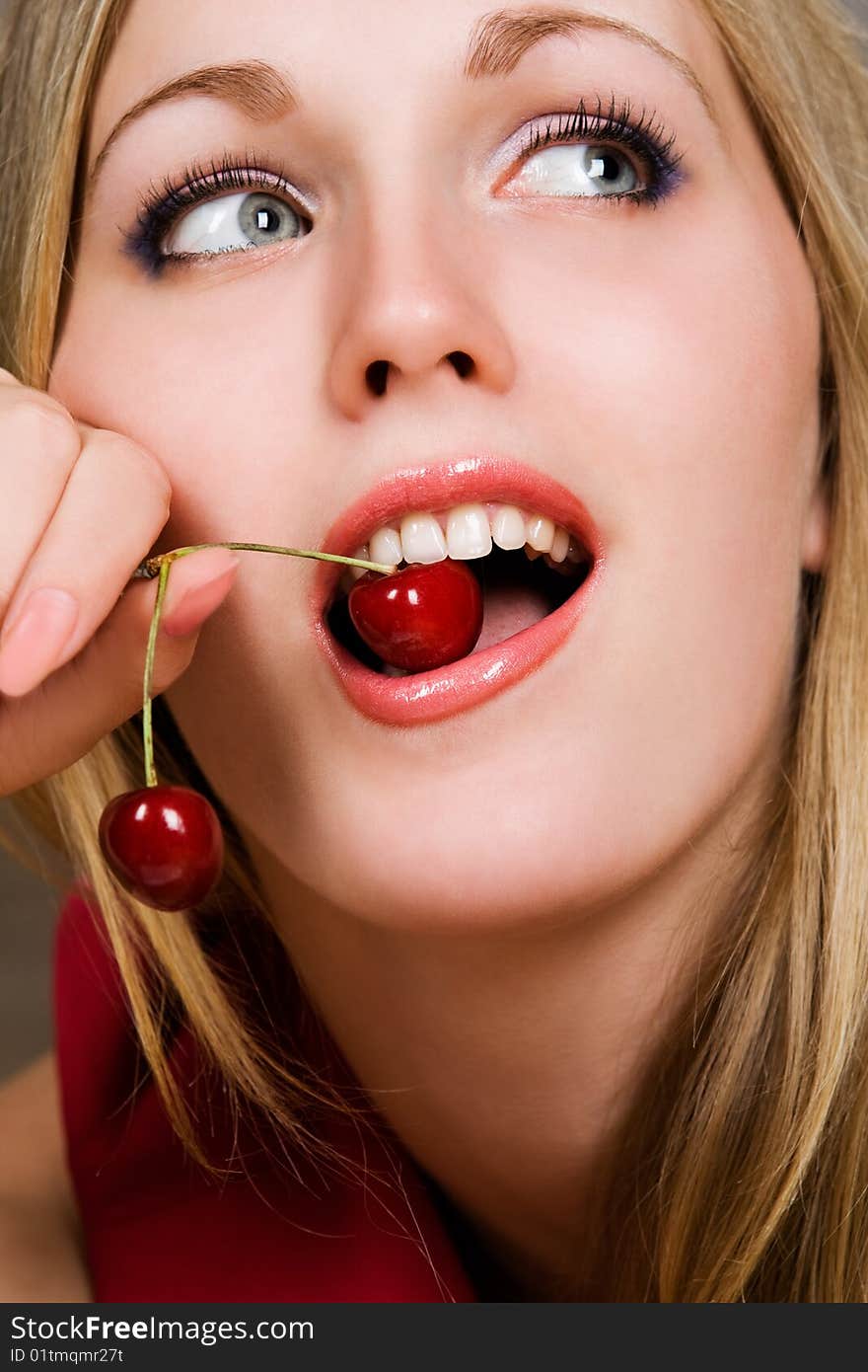 Healthy young woman eating red cherries