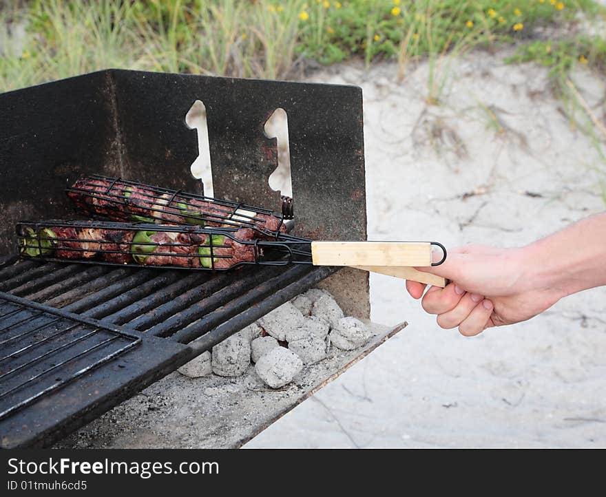 Grill meat cooking charcoal picnic beach hand. Grill meat cooking charcoal picnic beach hand