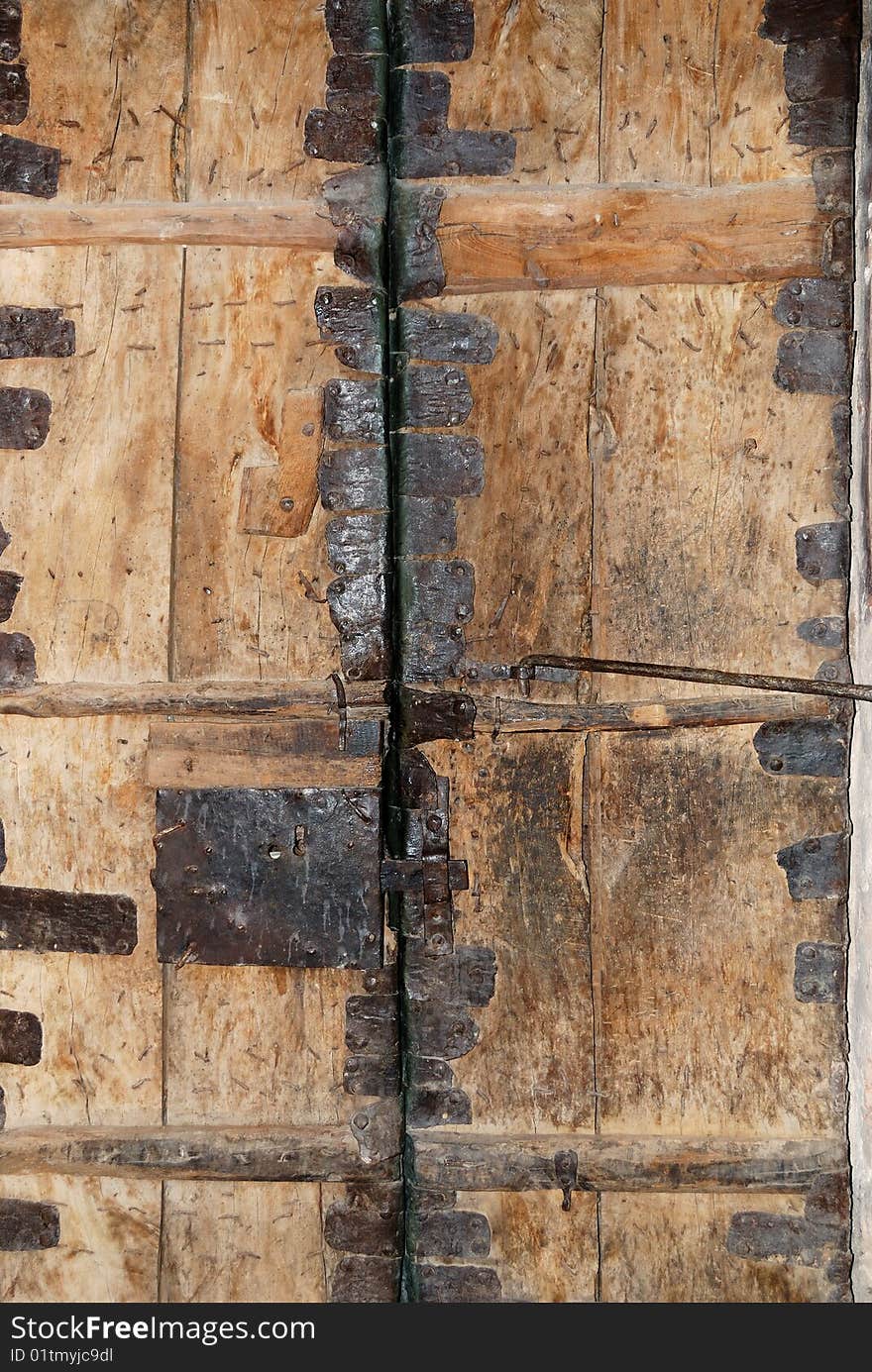 Old rusty wooden gate strengthened by iron elements. Old rusty wooden gate strengthened by iron elements