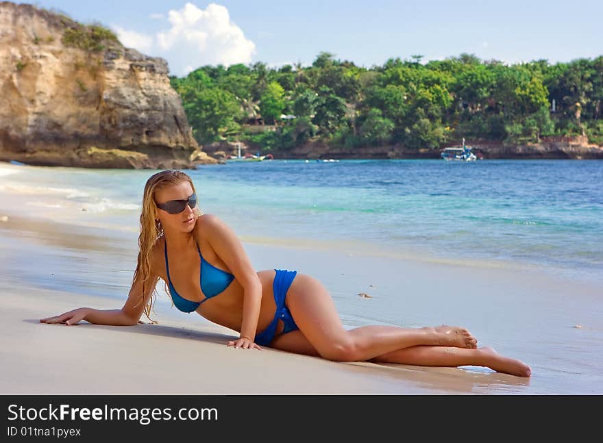 Blonde Lady Lying In Water On The Beach