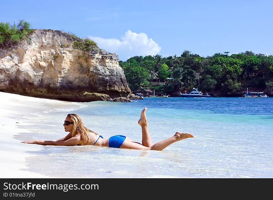 Blonde lady lying in water on the beach