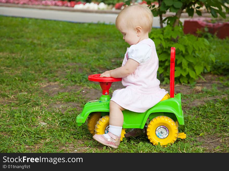 Little girl sitting on a green car