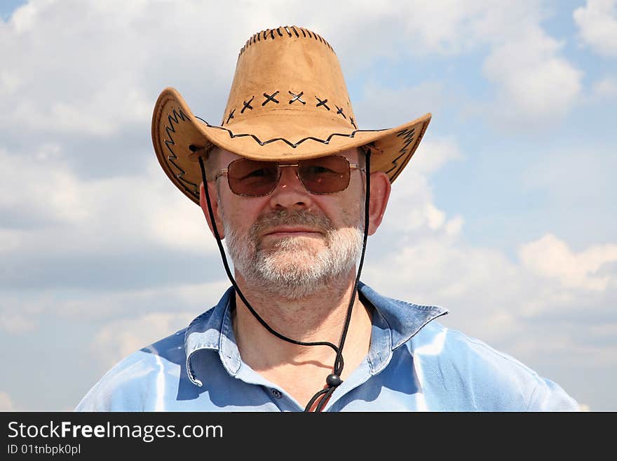 The man in a cowboys hat against the blue sky