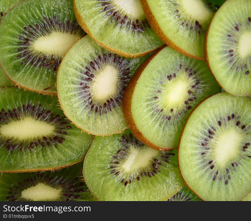 A lot of pieces kiwi fruit and an orange, a background. A lot of pieces kiwi fruit and an orange, a background