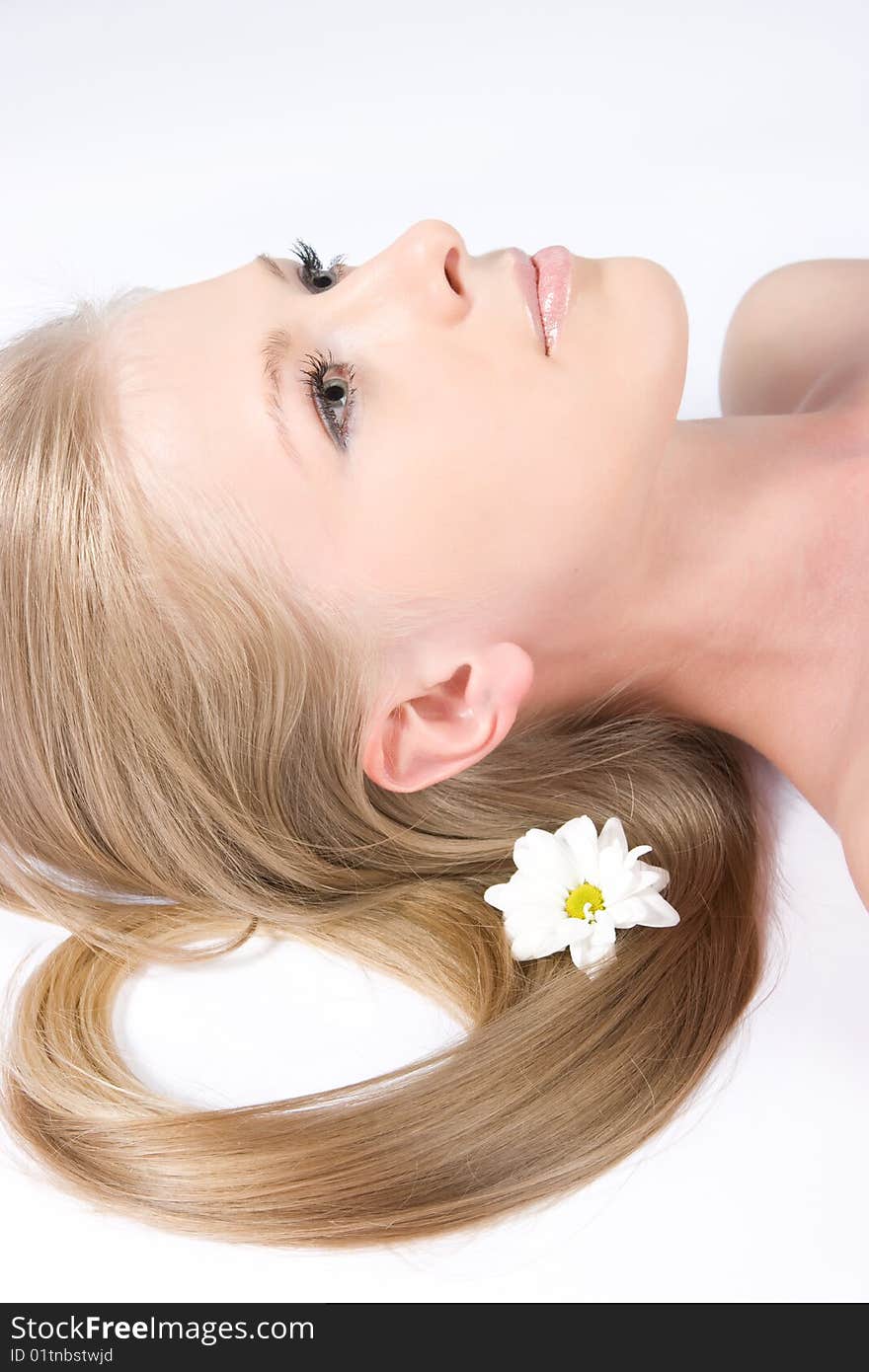 Close-up beautiful young fresh blonde lady relaxing with flower in her hair. Close-up beautiful young fresh blonde lady relaxing with flower in her hair