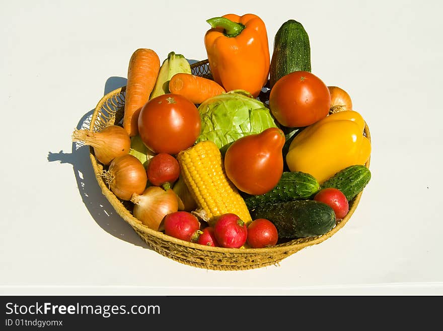 Basket with vegetables on white background