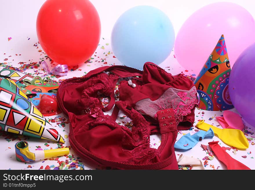 Ladies pants laying at a floor filled with party attributes, balloons and confetti. Ladies pants laying at a floor filled with party attributes, balloons and confetti