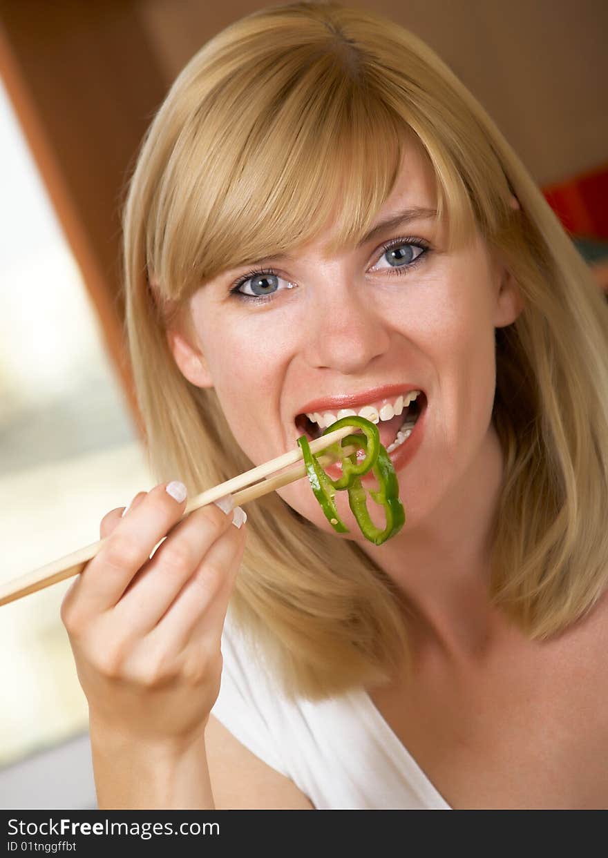 The young woman eats green salad. The young woman eats green salad