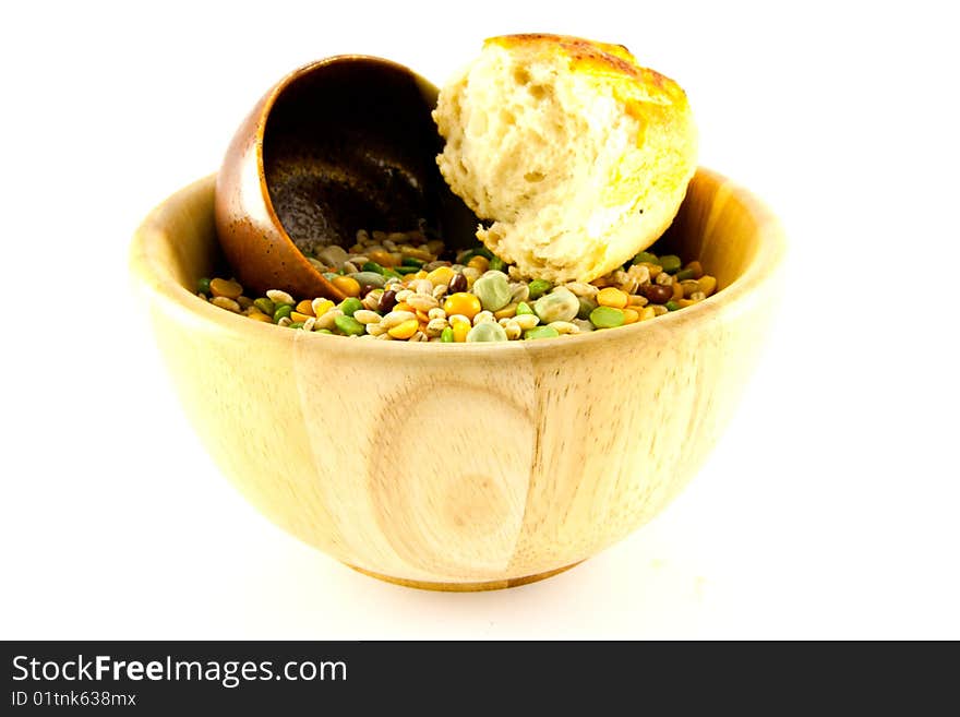 Wooden bowl of soup pulses with crusty bread on a white background. Wooden bowl of soup pulses with crusty bread on a white background