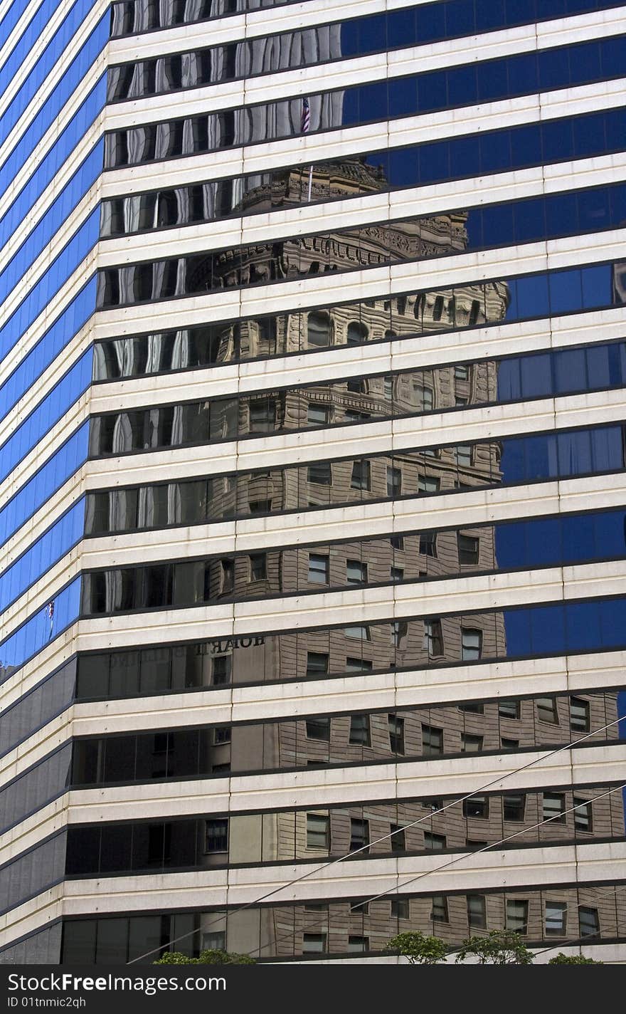 Reflection of an old skyscraper in the windows of new skyscrapers in the financial department of San Francisco. USA.