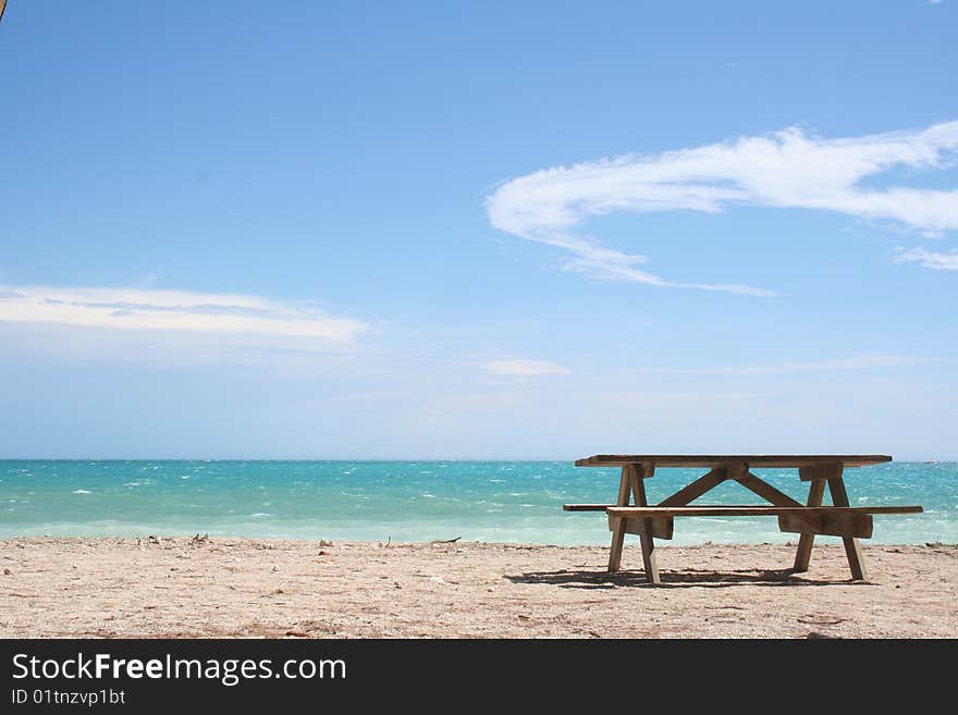 A bench rests on a beach in key west, florida. A bench rests on a beach in key west, florida