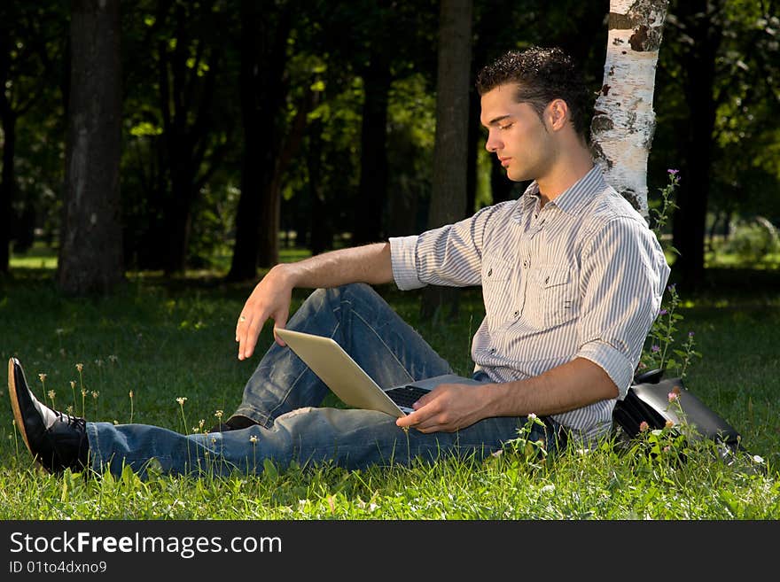 Businessman working with his laptop in the park. Businessman working with his laptop in the park