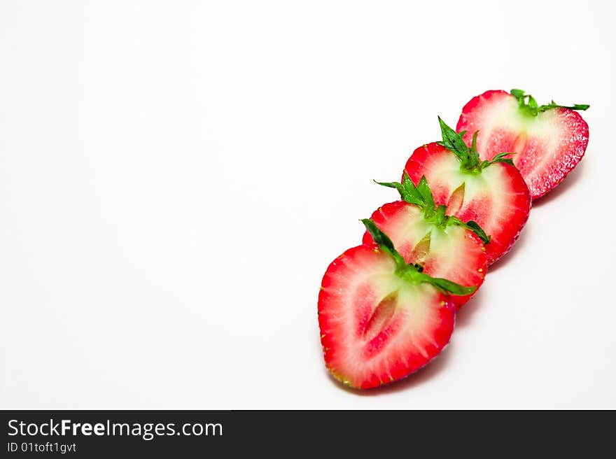 Row of freshly sliced strawberries on white background. Row of freshly sliced strawberries on white background