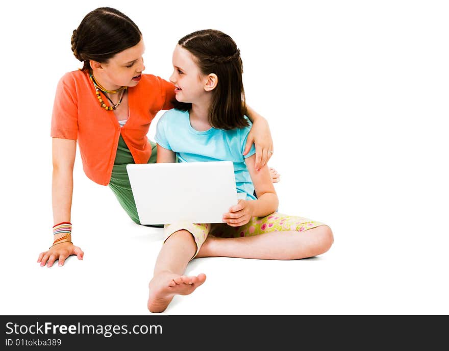 Smiling girls using a laptop isolated over white