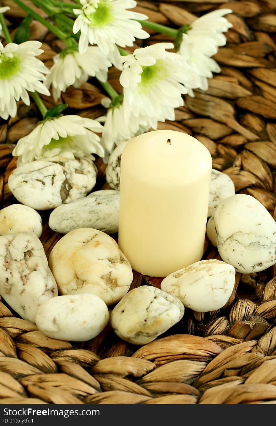 Spa concept. Candle, stones and white flowers.