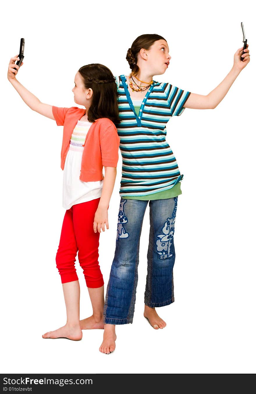 Two girls photo messaging on mobile phones isolated over white