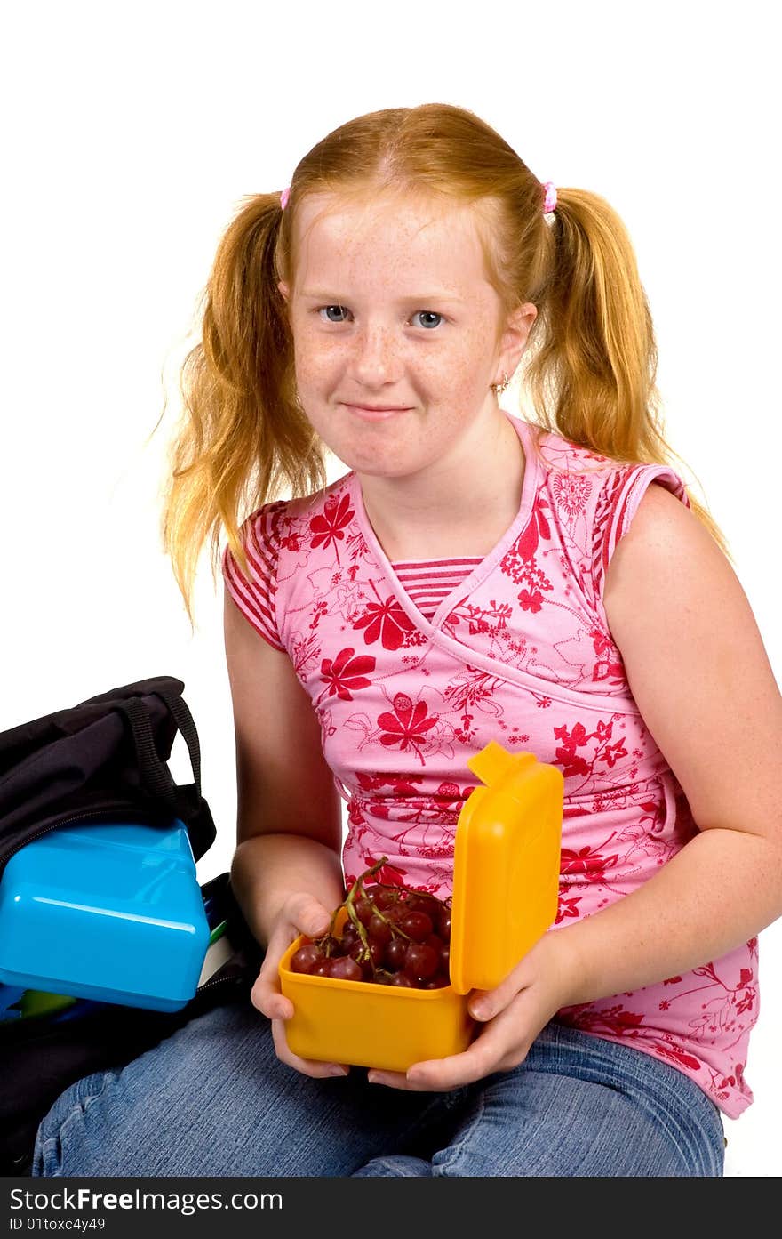 Schoolgirl is having grapes as lunch isolated on white