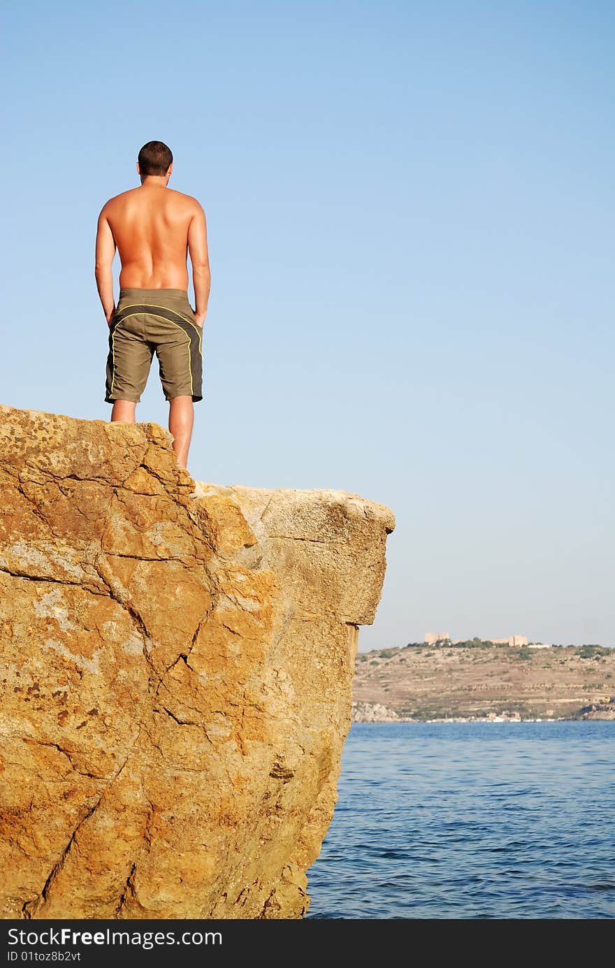 Man standing on top of cliff. Man standing on top of cliff