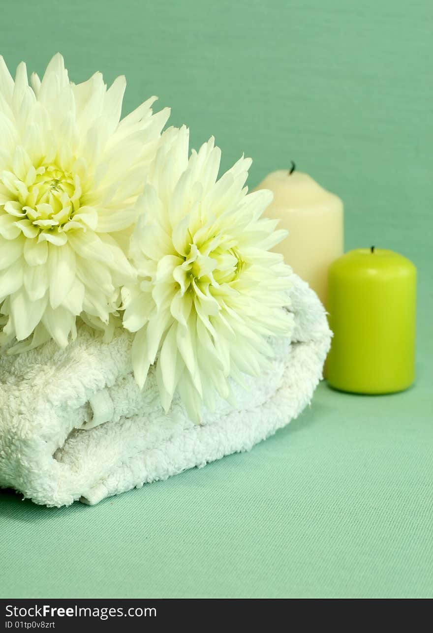 Spa essentials. Towel, candles and white flowers.