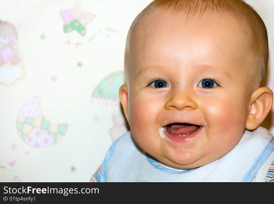 Portrait of happy baby after feeding. Baby is smiling and sitting on baby's chair. Baby's face is messy. Portrait of happy baby after feeding. Baby is smiling and sitting on baby's chair. Baby's face is messy.