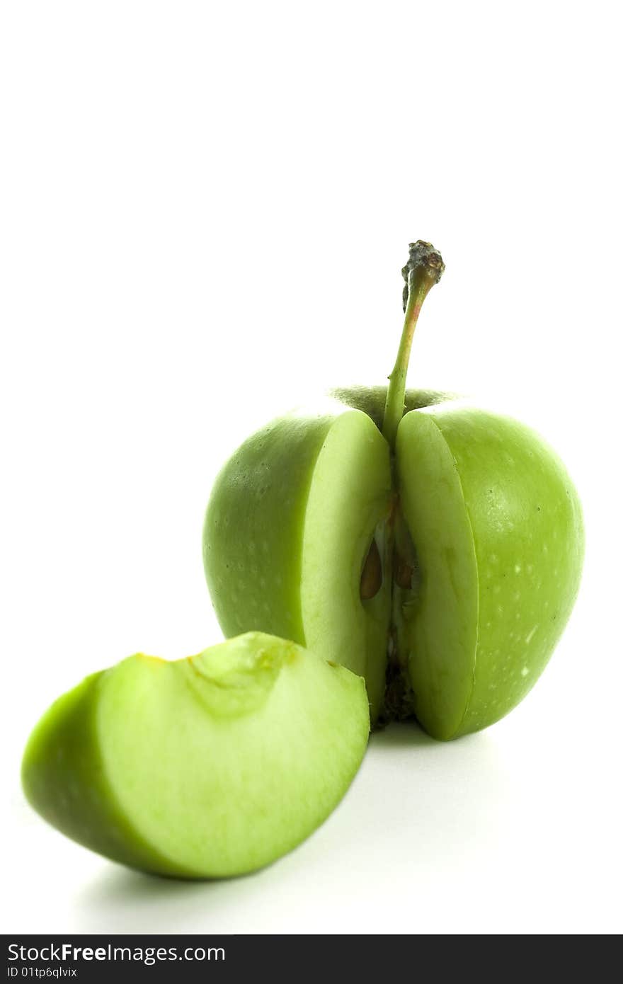 A green and sliced apple isolated with a white background. A green and sliced apple isolated with a white background