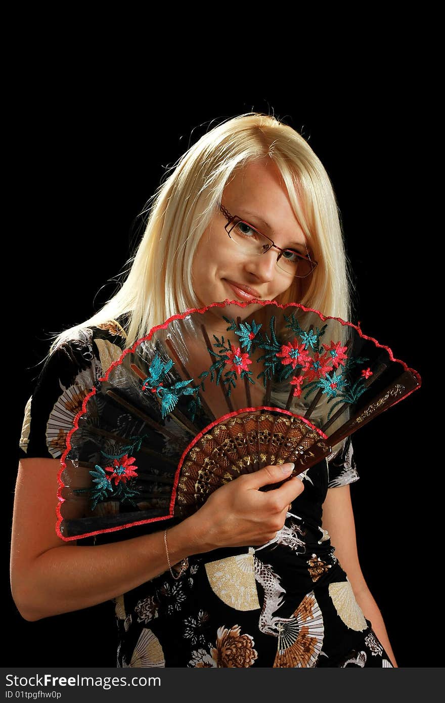 A young attractive woman with fan, isolated on black background