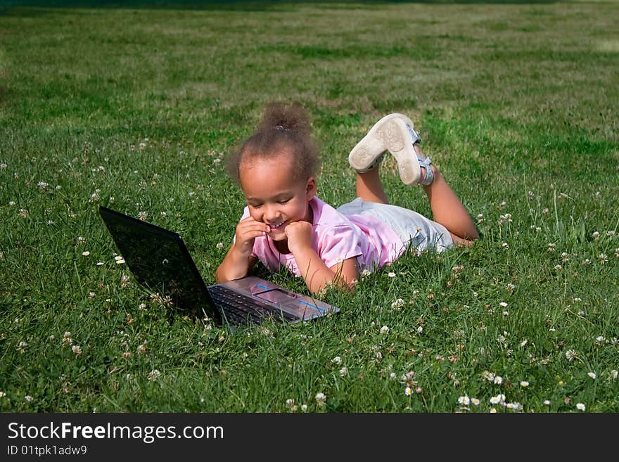 Young Girl in Green Grass with Laptop Computer