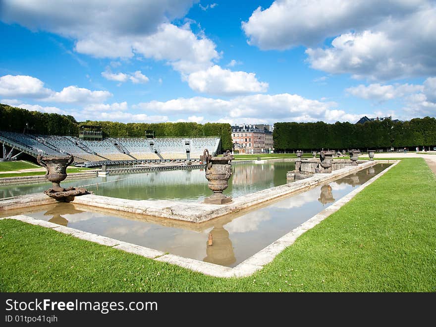 Classic fountain in paris royal park with water reflection