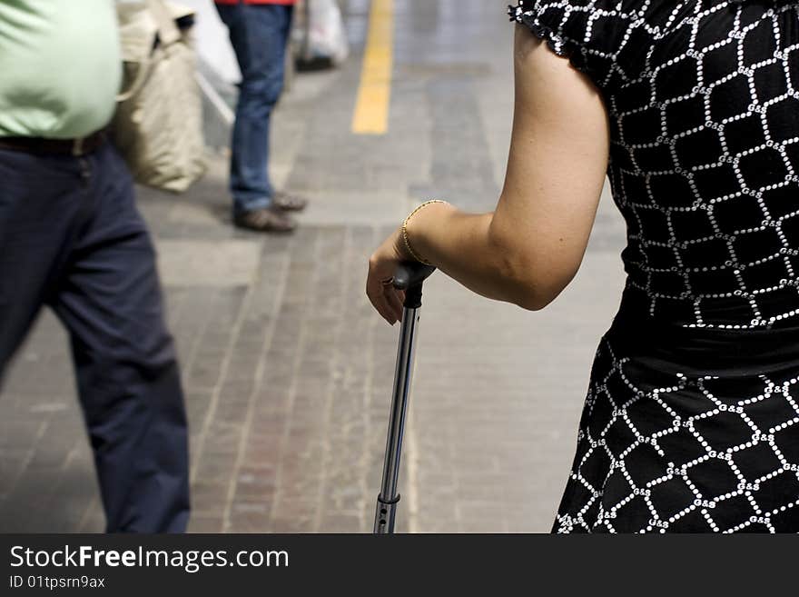 Woman with trolley waiting in the railway station