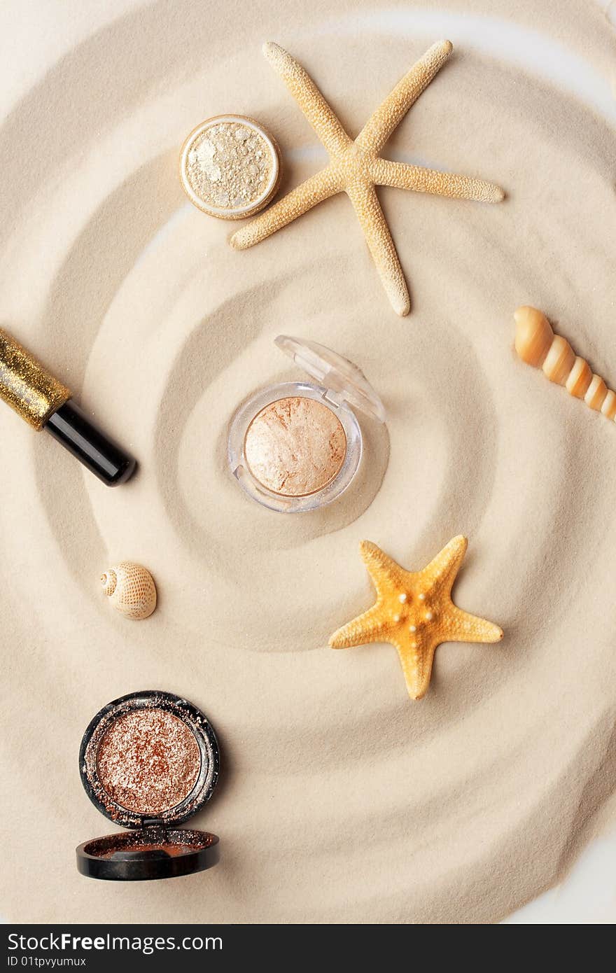 Starfishes, eyeshadow and glitter on the sand. Starfishes, eyeshadow and glitter on the sand