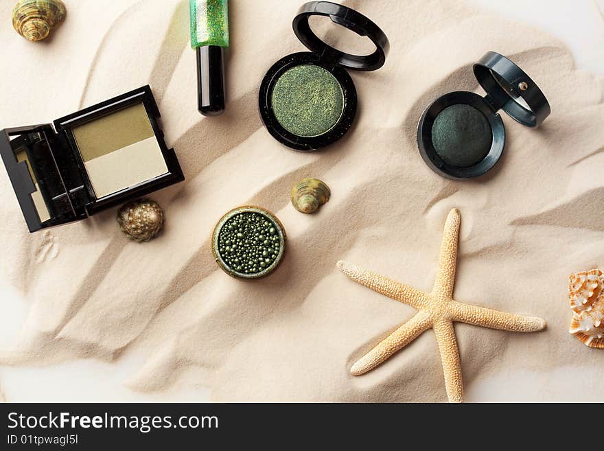 Starfishes, eyeshadow and glitter on the sand. Starfishes, eyeshadow and glitter on the sand