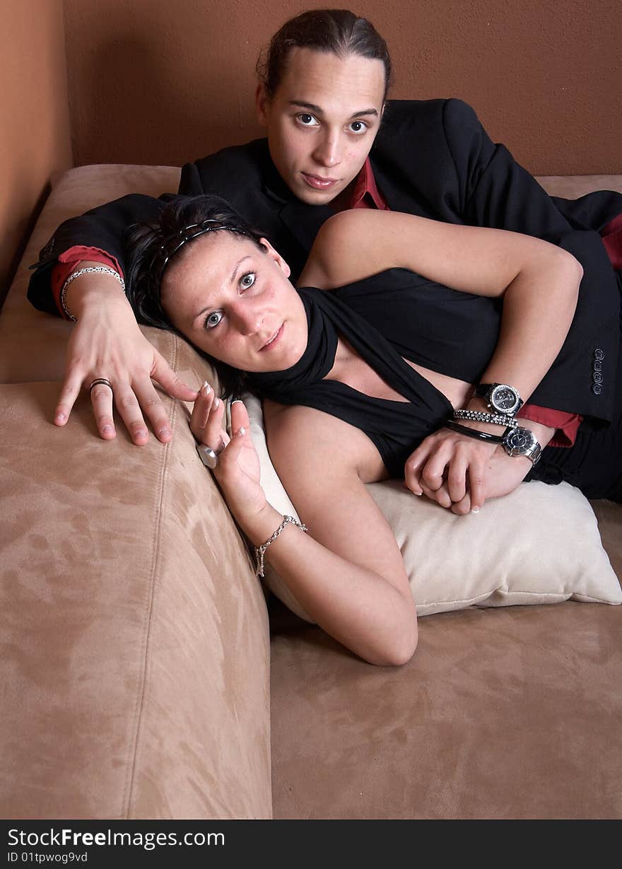 Young couple chilling on a couch at home. Both dressed up nicely. Young couple chilling on a couch at home. Both dressed up nicely.