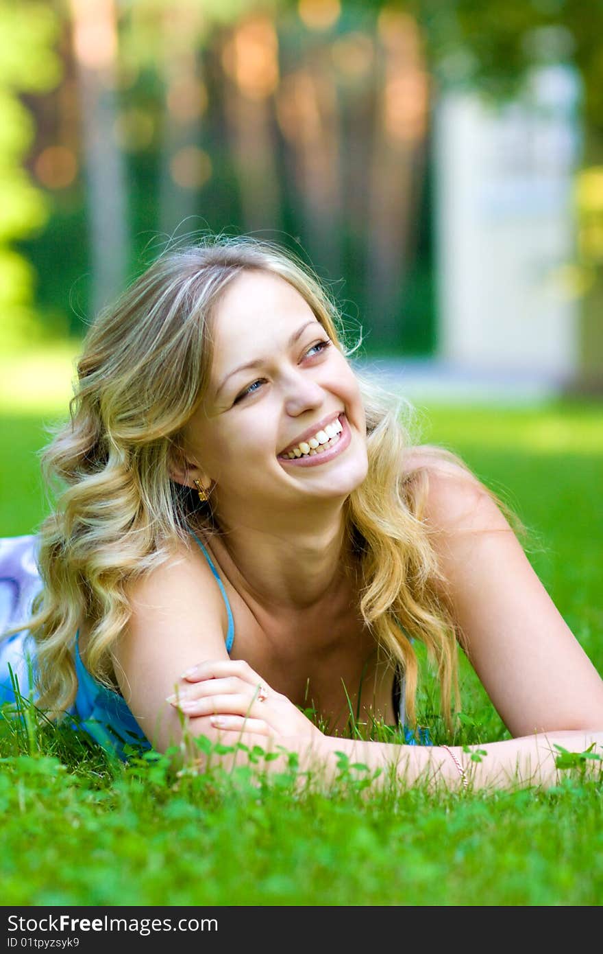 Young woman lying on a green grass