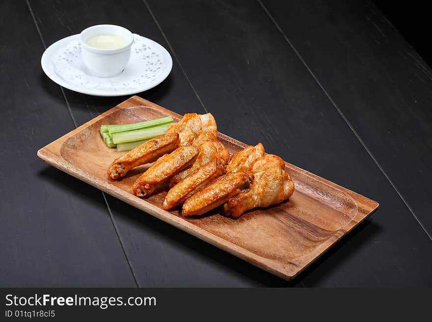 Grilled chicken wings served on wooden board