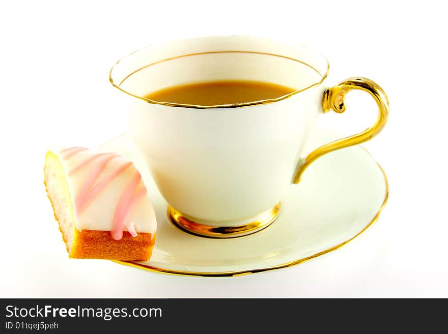 Tea in a cup and saucer with pink slice of cake on a white background. Tea in a cup and saucer with pink slice of cake on a white background