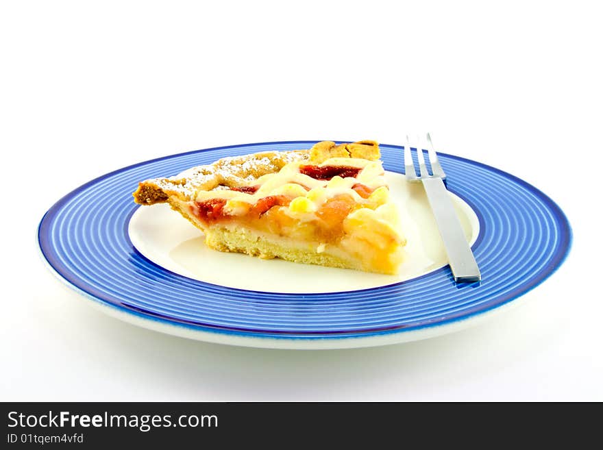 Slice of strawberry and apple pie on a blue plate with a small fork on a white background. Slice of strawberry and apple pie on a blue plate with a small fork on a white background