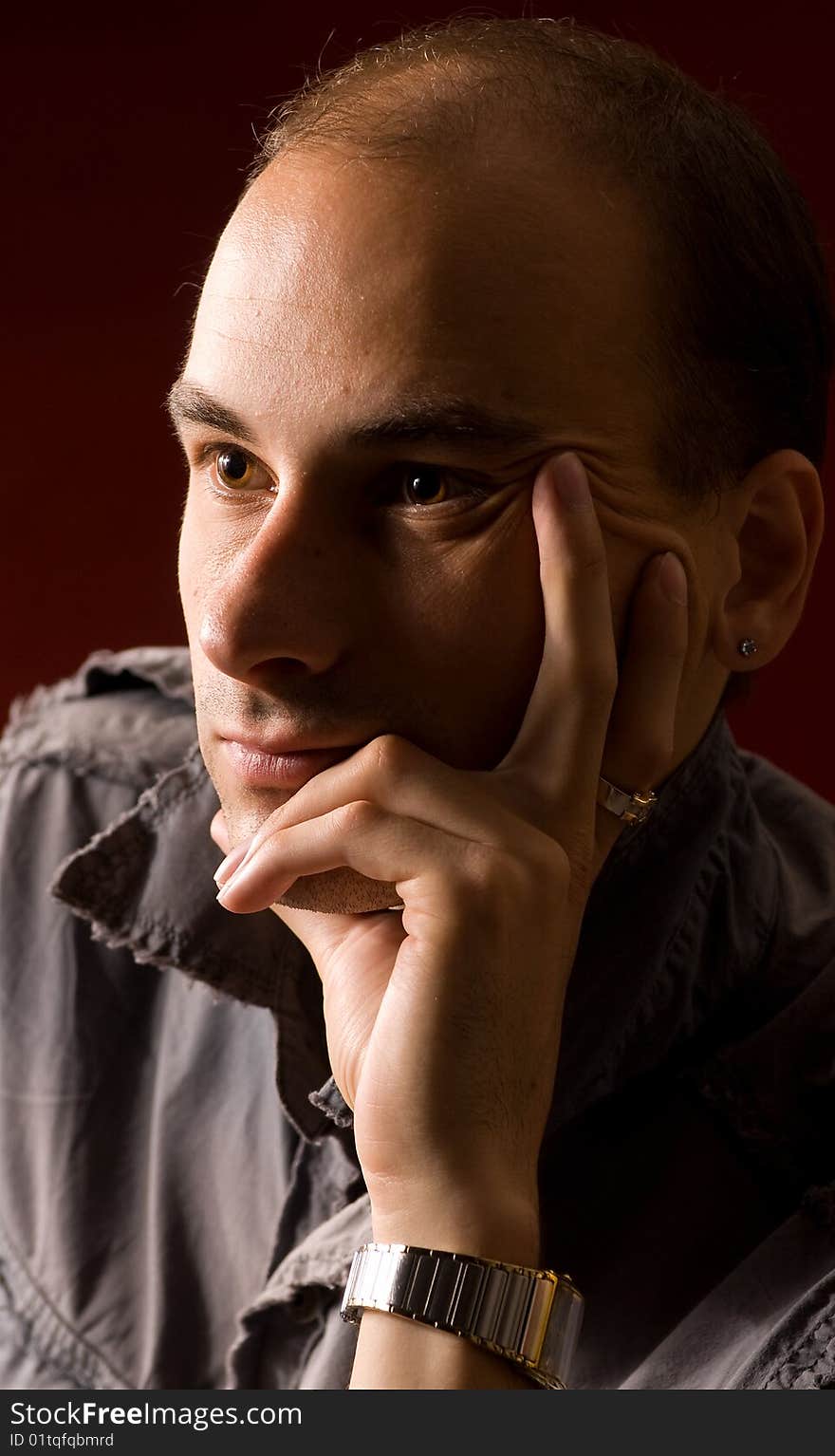 Young man portrait thinking. Dark background.