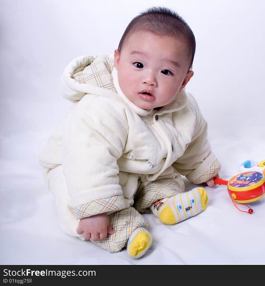 A baby sitting on the white background. A baby sitting on the white background