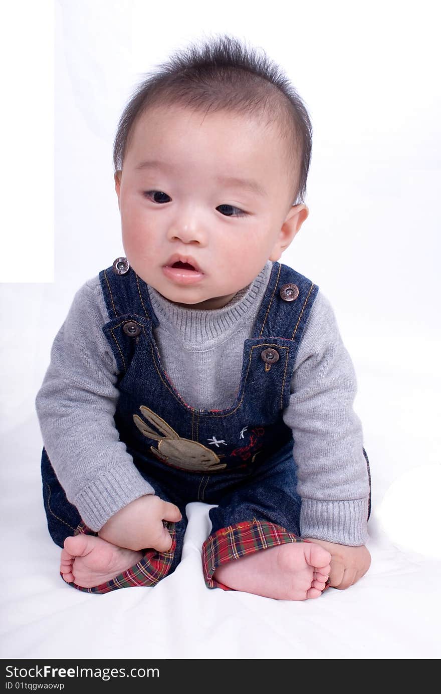 A baby sitting on the white background. A baby sitting on the white background