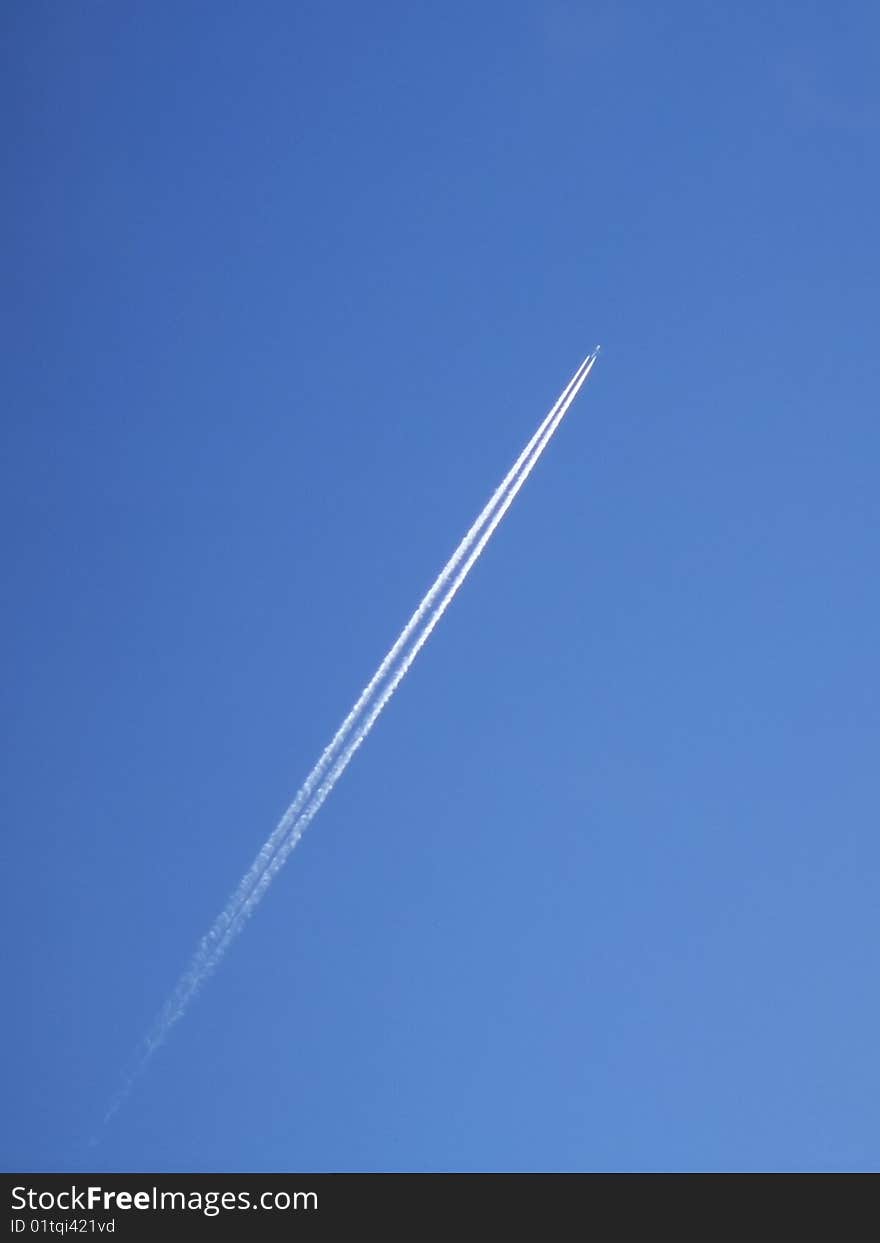 Contrail of a jet airliner high in a clear blue sky