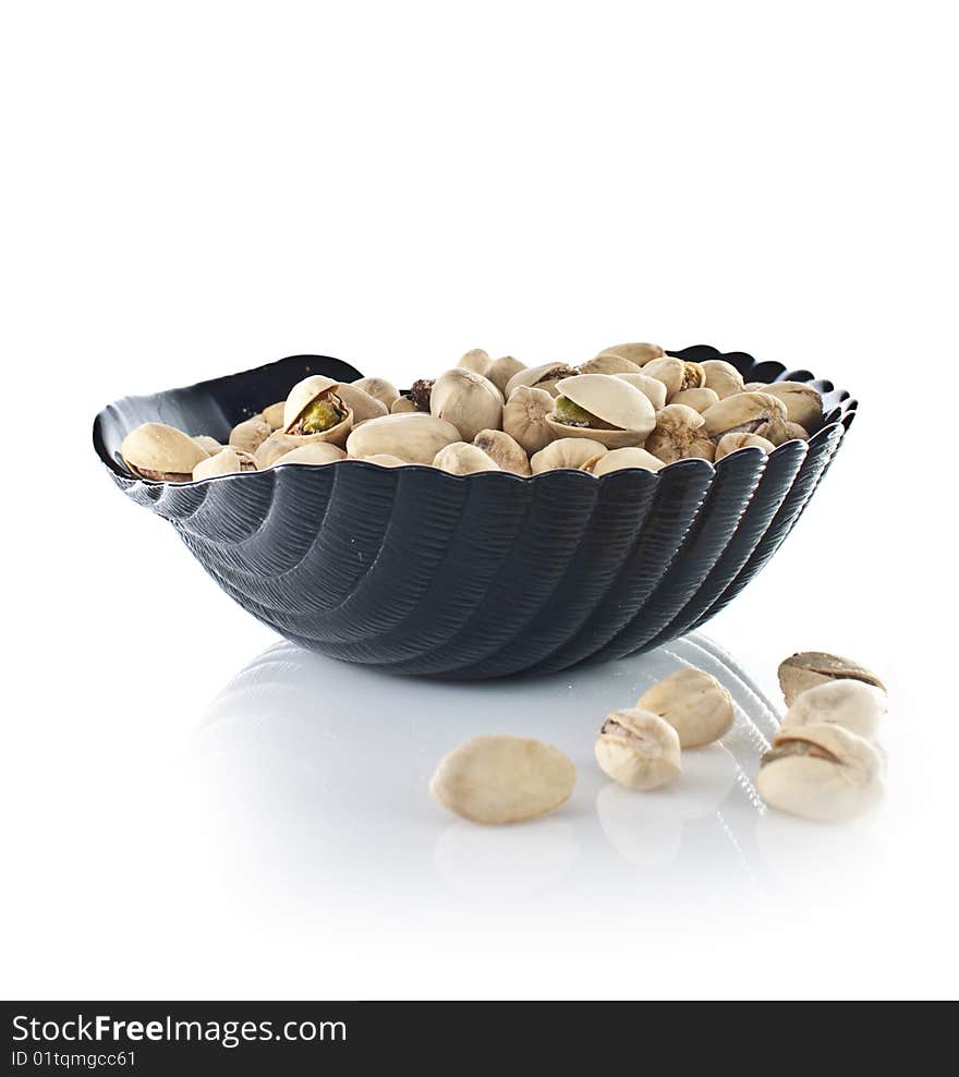 Bowl of pistachios on white backround