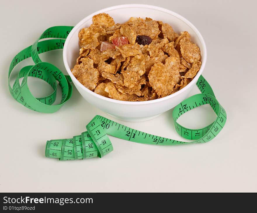 Measurement tape wrapped around dish with flakes/Concept for health, diet