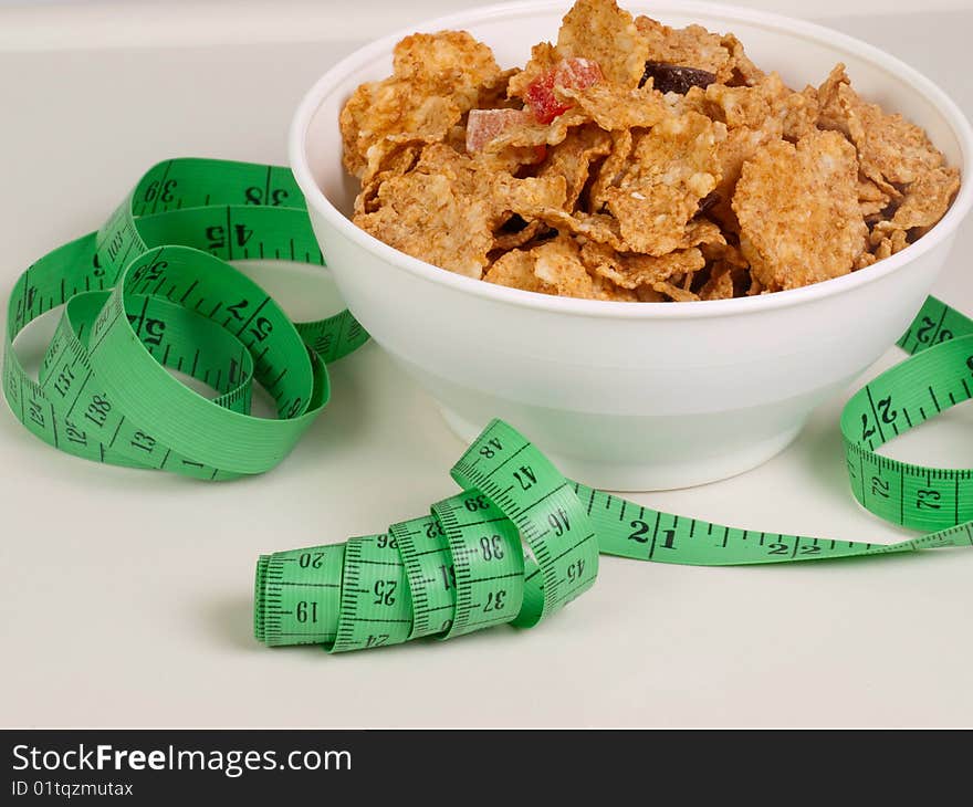 Measurement tape wrapped around dish with flakes/Concept for health, diet