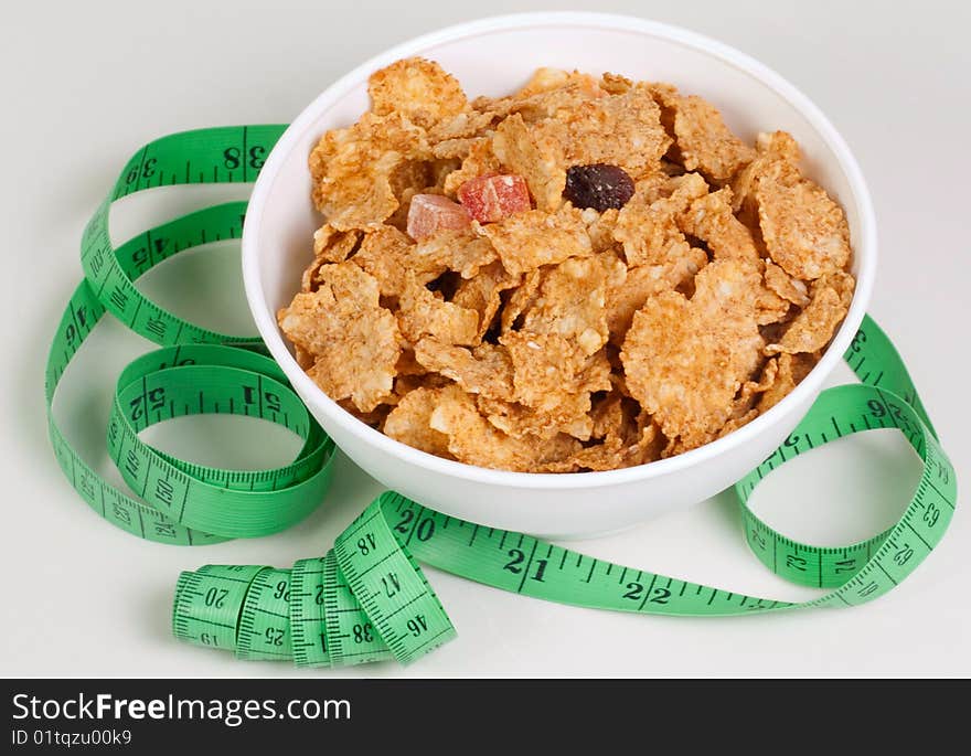 Measurement tape wrapped around dish with flakes/Concept for health, diet