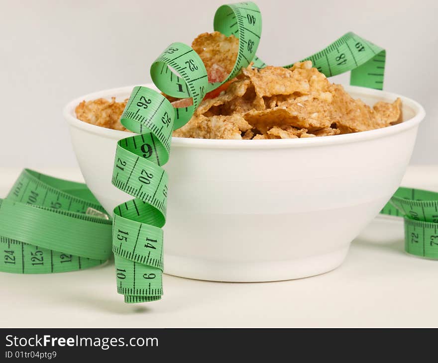 Measurement tape wrapped around dish with flakes/Concept for health, diet